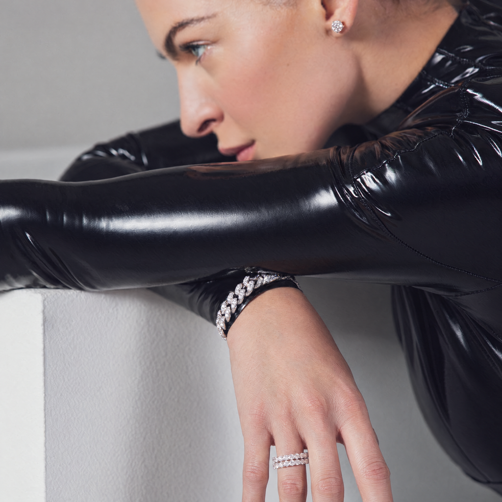 Model wearing the H. Moissan Studs with a moissanite Cuban link bracelet and stacked eternity rings